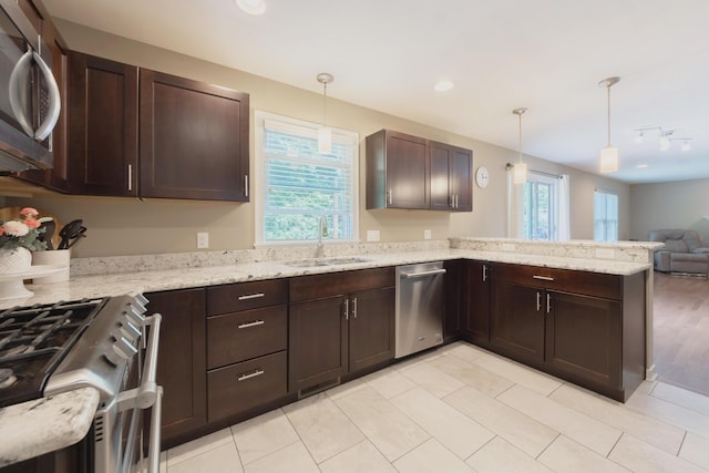 1481 Kristen Path, Saint Joseph, MI 49085 - kitchen featuring appliances with stainless steel finishes, open floor plan, dark brown cabinets, a peninsula, and hanging light fixtures