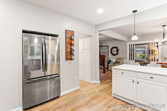 15405 Barry St, West Olive, MI 49460 - kitchen featuring stainless steel fridge, white cabinetry, light wood-type flooring, open floor plan, and light countertops