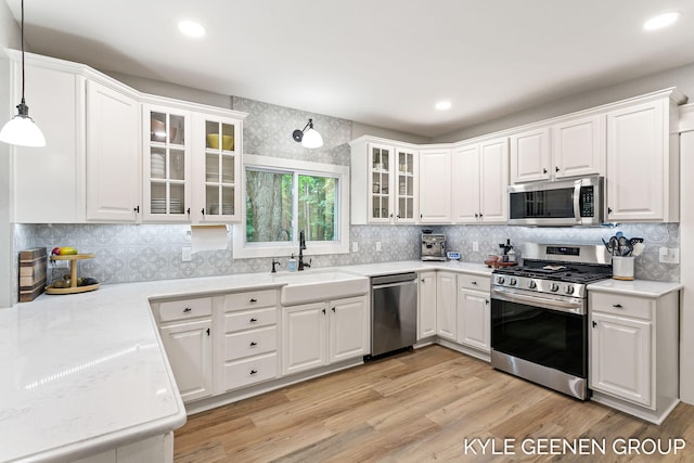 15405 Barry St, West Olive, MI 49460 - kitchen with appliances with stainless steel finishes, white cabinetry, light wood-type flooring, and recessed lighting