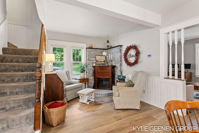 15405 Barry St, West Olive, MI 49460 - living area with wood finished floors, stairway, wainscoting, and a brick fireplace
