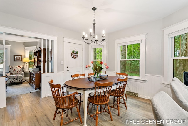 15405 Barry St, West Olive, MI 49460 - dining area featuring a wainscoted wall, light wood finished floors, healthy amount of natural light, and a chandelier