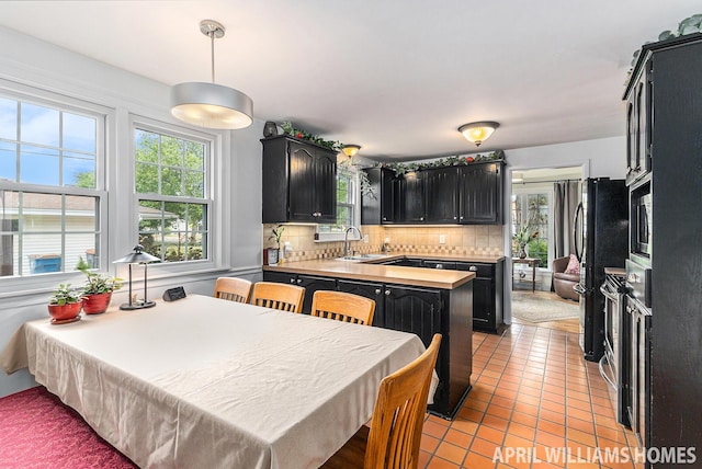 740 Van Raalte Ave, Holland, MI 49423 - kitchen featuring dark cabinets, plenty of natural light, backsplash, and light tile patterned floors