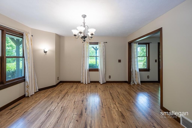 3192 W Sisson Rd, Freeport, MI 49325 - unfurnished room featuring healthy amount of natural light, a chandelier, and light wood finished floors