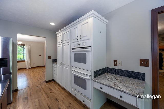3192 W Sisson Rd, Freeport, MI 49325 - kitchen with double oven, stainless steel refrigerator with ice dispenser, white cabinets, hardwood / wood-style flooring, and recessed lighting