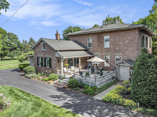 14011 Verona Rd, Marshall, MI 49068 - view of front of house with brick siding, a shed, a chimney, a shingled roof, and a front yard