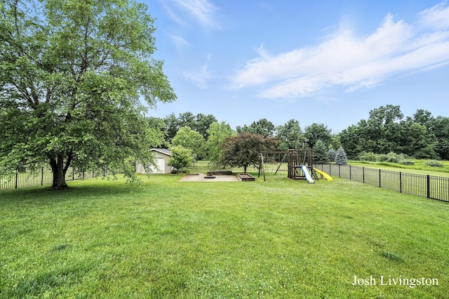 9337 Andrew Farms Dr, Alto, MI 49302 - fenced backyard featuring a playground and an outdoor fire pit