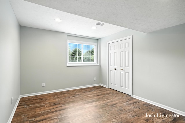 9337 Andrew Farms Dr, Alto, MI 49302 - unfurnished bedroom featuring wood finished floors, a textured ceiling, a closet, and recessed lighting