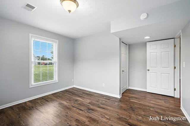 9337 Andrew Farms Dr, Alto, MI 49302 - unfurnished bedroom with baseboards and dark wood-type flooring