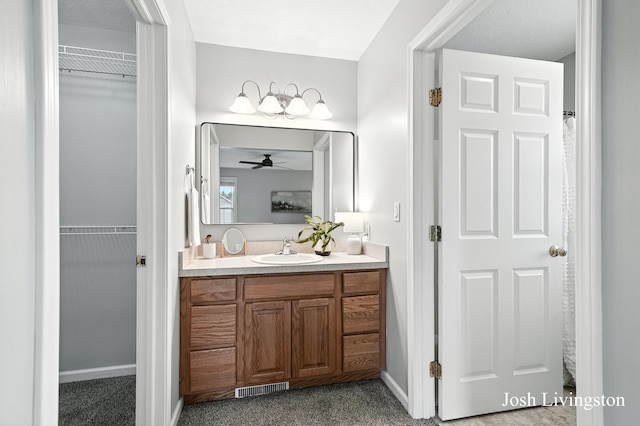 9337 Andrew Farms Dr, Alto, MI 49302 - bathroom with vanity, a ceiling fan, and a spacious closet