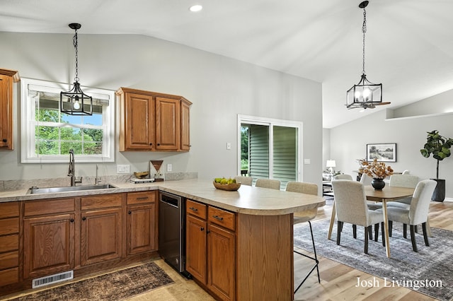 9337 Andrew Farms Dr, Alto, MI 49302 - kitchen featuring vaulted ceiling, dishwasher, a peninsula, light countertops, and a breakfast bar area