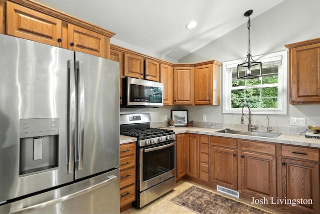 9337 Andrew Farms Dr, Alto, MI 49302 - kitchen with appliances with stainless steel finishes, vaulted ceiling, brown cabinets, pendant lighting, and recessed lighting