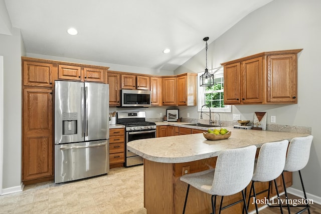 9337 Andrew Farms Dr, Alto, MI 49302 - kitchen with appliances with stainless steel finishes, lofted ceiling, a peninsula, light countertops, and brown cabinets