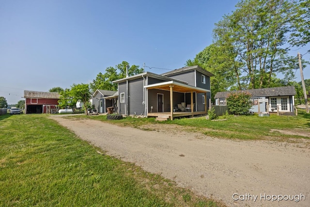 4555 Charles St, Palo, MI 48870 - view of front of house featuring a front yard, dirt driveway, a deck, and an outdoor structure