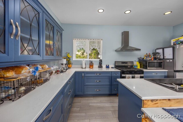 4555 Charles St, Palo, MI 48870 - kitchen featuring wall chimney exhaust hood, appliances with stainless steel finishes, blue cabinets, light countertops, and recessed lighting