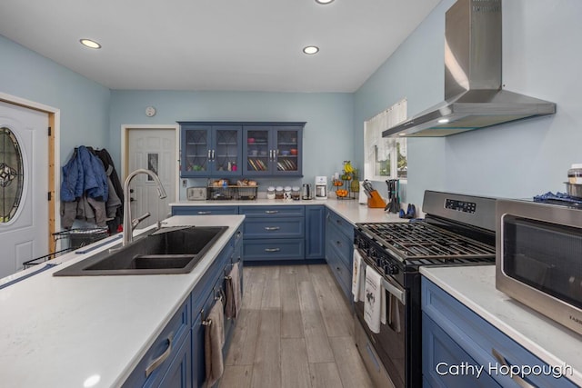 4555 Charles St, Palo, MI 48870 - kitchen with wall chimney range hood, stainless steel appliances, blue cabinetry, light countertops, and recessed lighting