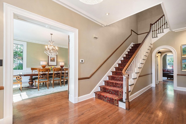 60 Lafayette Ave NE, Grand Rapids, MI 49503 - stairs with a chandelier, healthy amount of natural light, wood finished floors, arched walkways, and crown molding