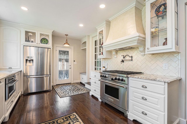 60 Lafayette Ave NE, Grand Rapids, MI 49503 - kitchen featuring appliances with stainless steel finishes, premium range hood, tasteful backsplash, light stone countertops, and dark wood-type flooring