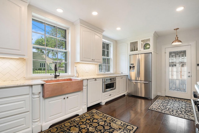60 Lafayette Ave NE, Grand Rapids, MI 49503 - kitchen with stainless steel appliances, white cabinets, dark wood-style floors, light stone counters, and tasteful backsplash