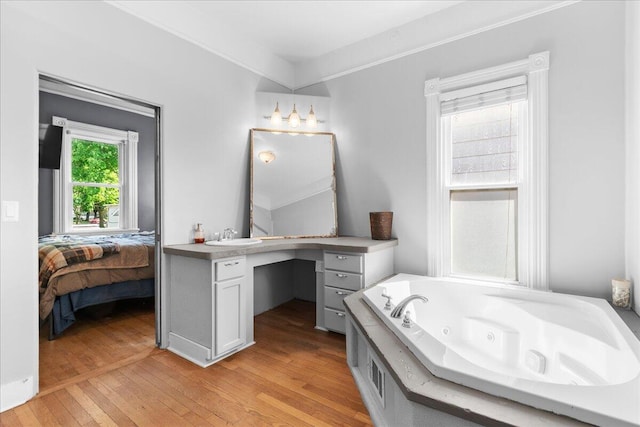 905 Harrison Ave, Saint Joseph, MI 49085 - ensuite bathroom with a whirlpool tub, vanity, and hardwood / wood-style floors