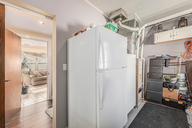 209 Maple St, Three Oaks, MI 49128 - kitchen featuring freestanding refrigerator, white cabinetry, and wood finished floors