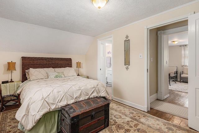 209 Maple St, Three Oaks, MI 49128 - bedroom with a textured ceiling, wood finished floors, lofted ceiling, and connected bathroom