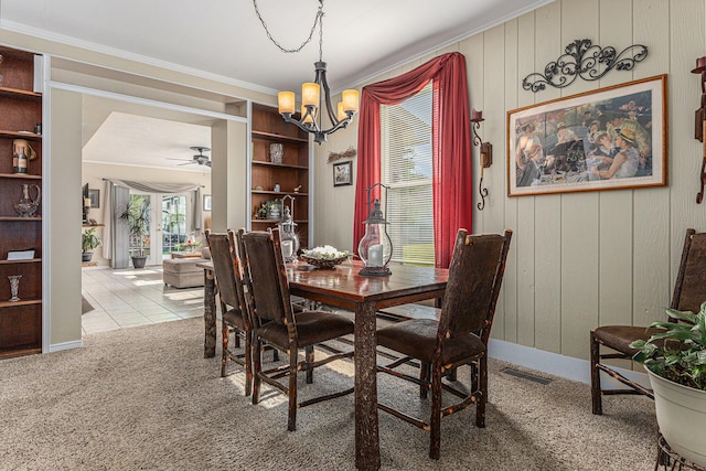 209 Maple St, Three Oaks, MI 49128 - dining space with a chandelier, ornamental molding, a ceiling fan, wood walls, and carpet