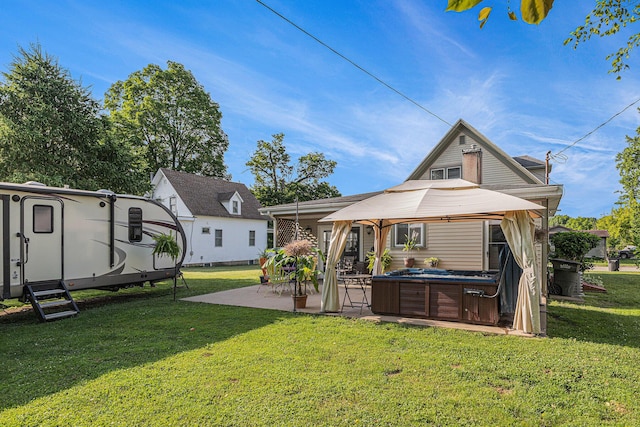 209 Maple St, Three Oaks, MI 49128 - back of house featuring a hot tub, a gazebo, a patio area, and a lawn