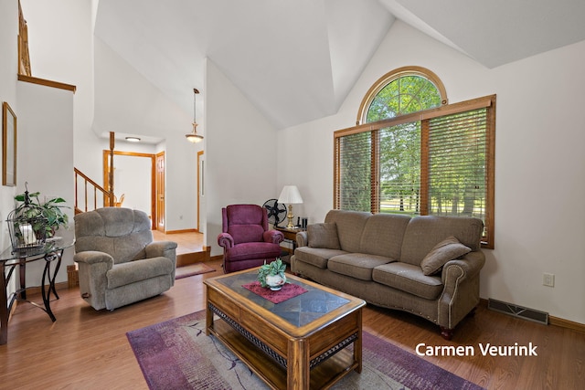 1723 S Sullivan Rd, Ravenna, MI 49451 - living area with wood finished floors, high vaulted ceiling, and stairs