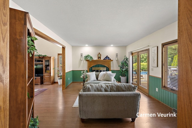 1723 S Sullivan Rd, Ravenna, MI 49451 - bedroom featuring a wainscoted wall, access to outside, wood finished floors, wooden walls, and a fireplace