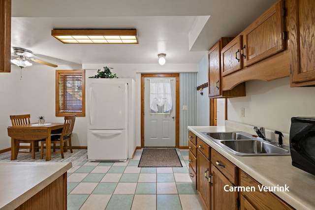 1723 S Sullivan Rd, Ravenna, MI 49451 - kitchen featuring freestanding refrigerator, brown cabinets, light countertops, and plenty of natural light