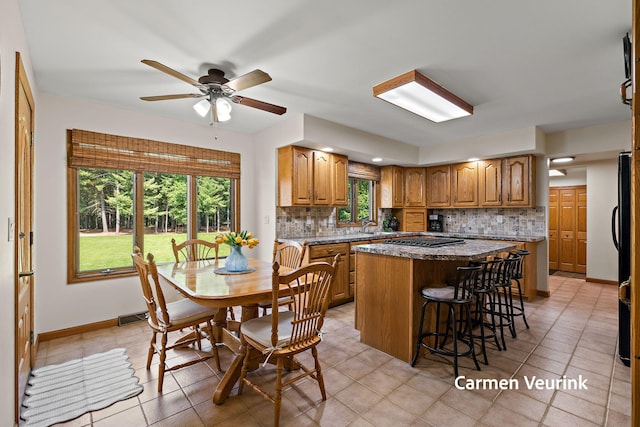 1723 S Sullivan Rd, Ravenna, MI 49451 - kitchen featuring a kitchen island, decorative backsplash, a ceiling fan, and a kitchen bar