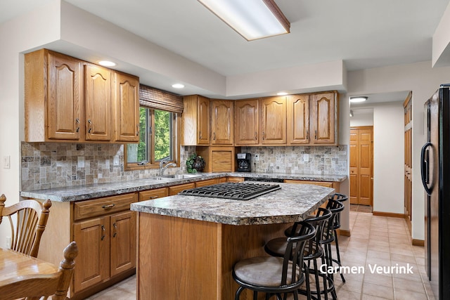 1723 S Sullivan Rd, Ravenna, MI 49451 - kitchen featuring freestanding refrigerator, a breakfast bar, a center island, light tile patterned floors, and tasteful backsplash