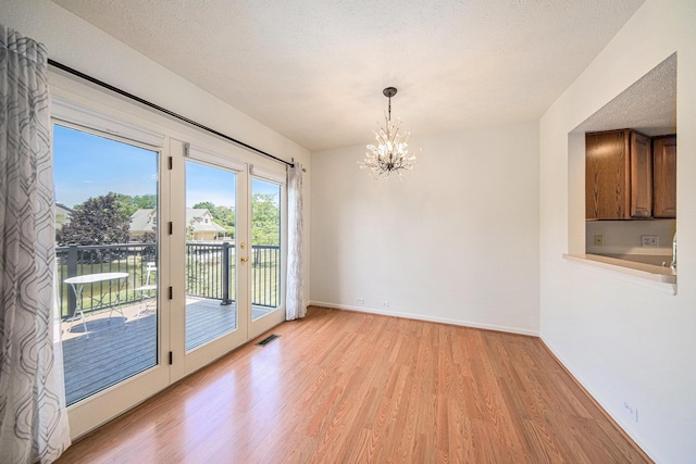 3350 Breckland Ct, Ann Arbor, MI 48108 - unfurnished dining area with light wood-style flooring and a chandelier