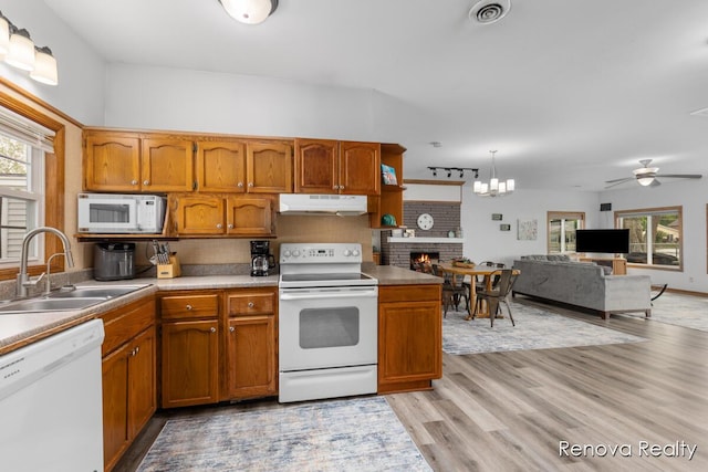 4278 W Joy Rd, Shelbyville, MI 49344 - kitchen with white appliances, under cabinet range hood, a fireplace, ceiling fan, and brown cabinets