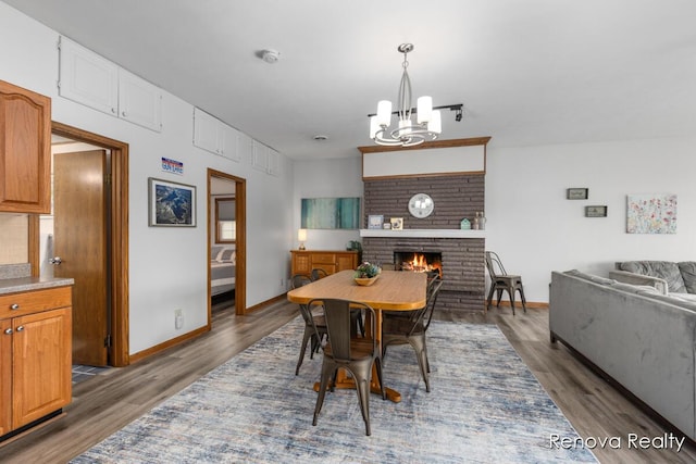 4278 W Joy Rd, Shelbyville, MI 49344 - dining room featuring a chandelier, a brick fireplace, and wood finished floors
