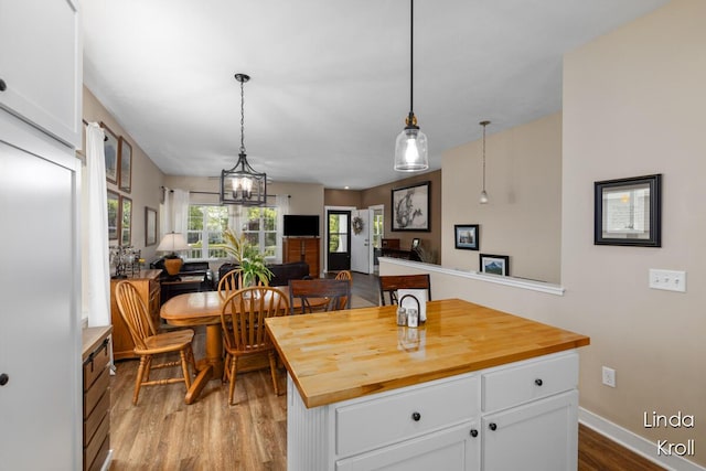 195 Liberty St NW, Sparta, MI 49345 - kitchen with wooden counters, wood finished floors, white cabinets, and hanging light fixtures