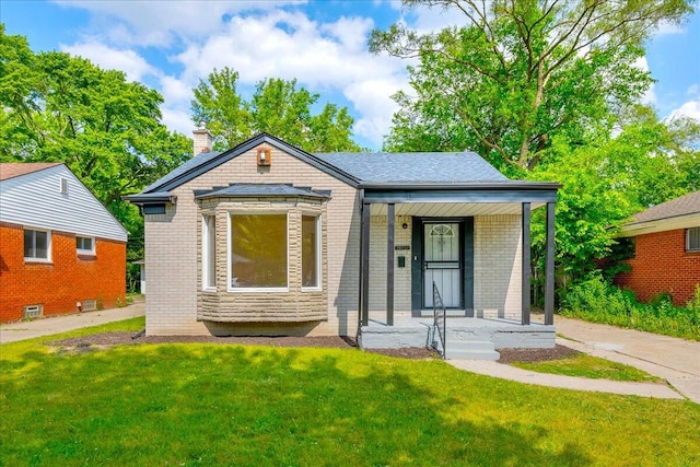 20232 Braile St, Detroit, MI 48219 - view of front facade with covered porch, brick siding, a front yard, and a chimney