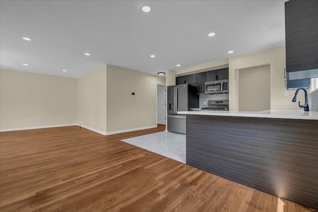 20232 Braile St, Detroit, MI 48219 - kitchen featuring stainless steel appliances, light countertops, wood finished floors, modern cabinets, and a peninsula