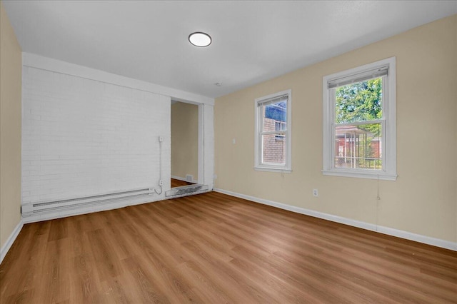 20232 Braile St, Detroit, MI 48219 - empty room with baseboard heating, light wood-type flooring, and brick wall
