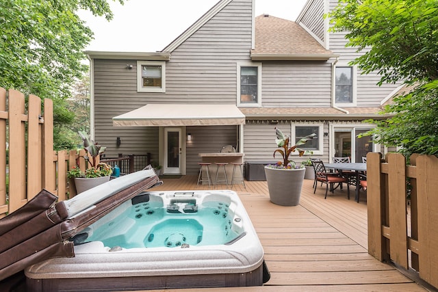 3185 Shadberry Ct, Saline, MI 48176 - rear view of house with a deck, outdoor dining area, a covered hot tub, and a shingled roof