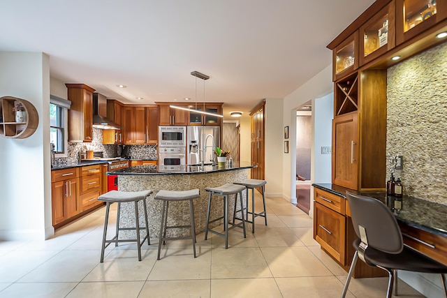 3185 Shadberry Ct, Saline, MI 48176 - kitchen with appliances with stainless steel finishes, decorative backsplash, light tile patterned floors, a breakfast bar area, and wall chimney range hood