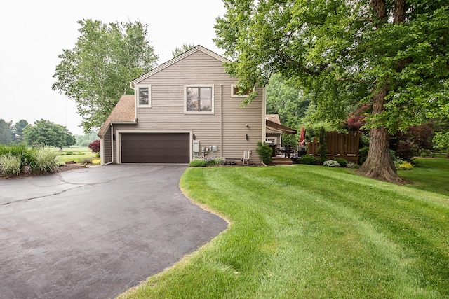 3185 Shadberry Ct, Saline, MI 48176 - view of property exterior with an attached garage, asphalt driveway, and a yard