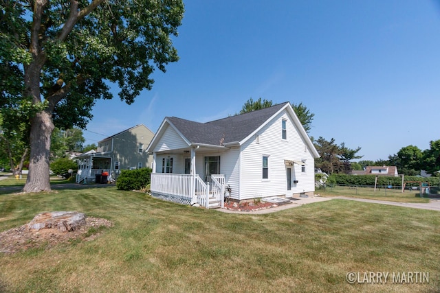 641 52nd St SE, Grand Rapids, MI 49548 - view of side of home with a lawn, covered porch, and roof with shingles