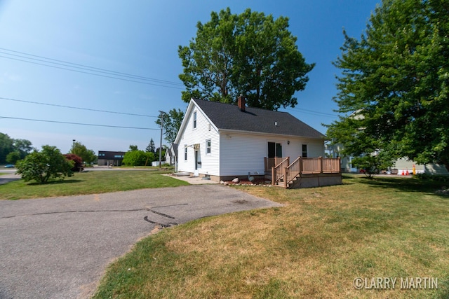 641 52nd St SE, Grand Rapids, MI 49548 - view of front of home with a deck, a front lawn, and a chimney