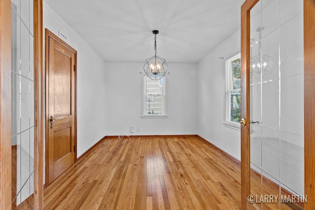 641 52nd St SE, Grand Rapids, MI 49548 - unfurnished dining area featuring light wood finished floors and a chandelier