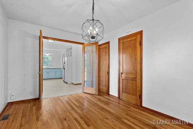 641 52nd St SE, Grand Rapids, MI 49548 - spare room featuring light wood finished floors and a chandelier