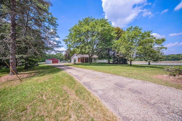 6990 Kennedy Rd, Munith, MI 49259 - view of front of home featuring a garage, a front lawn, an outdoor structure, and asphalt driveway