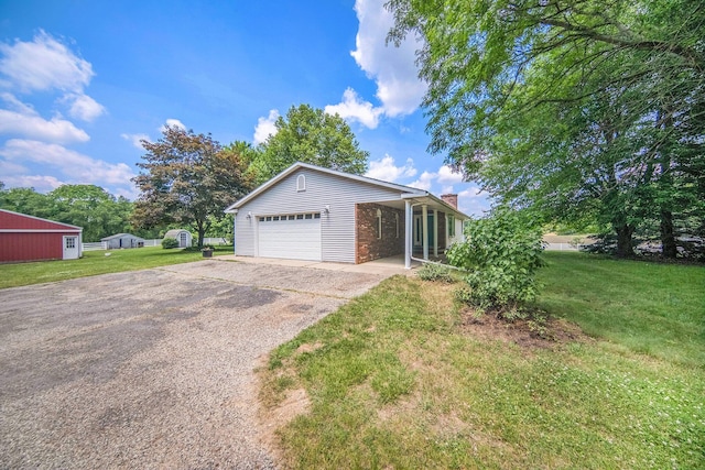 6990 Kennedy Rd, Munith, MI 49259 - view of front facade with asphalt driveway, a front lawn, a chimney, and a garage