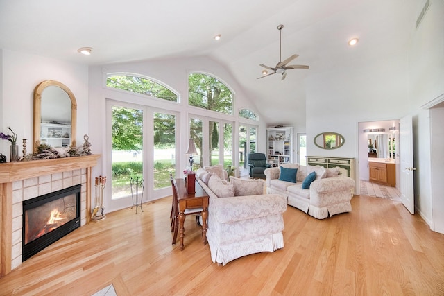6990 Kennedy Rd, Munith, MI 49259 - living area featuring a tile fireplace, a ceiling fan, light wood finished floors, and high vaulted ceiling