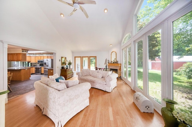6990 Kennedy Rd, Munith, MI 49259 - living area featuring high vaulted ceiling, a ceiling fan, light wood finished floors, and a fireplace
